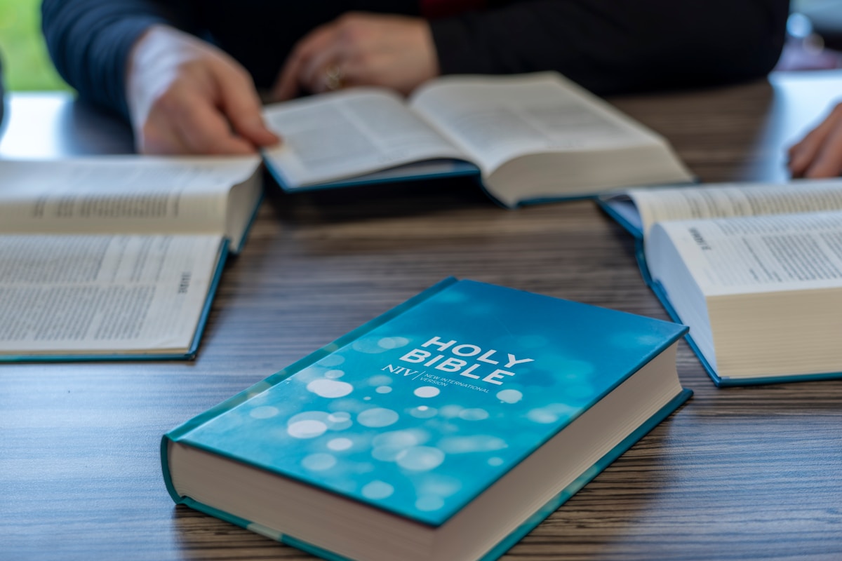 two people sitting at a table with open books
